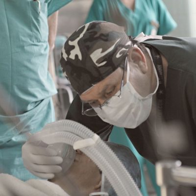 Médicos e enfermeiros atendem um paciente durante um procedimento hospitalar.