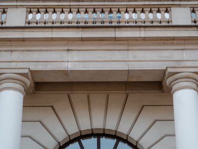 Fachada de prédio público neoclássico com colunas e sacada, vista durante o dia