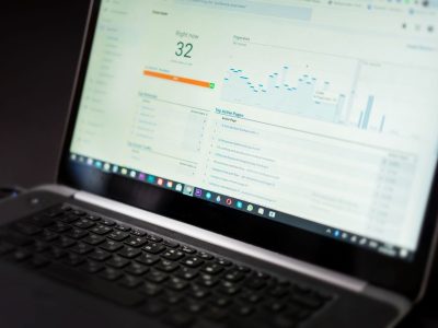 Laptop exibindo um painel de análise de dados em tempo real sobre uma mesa de trabalho.